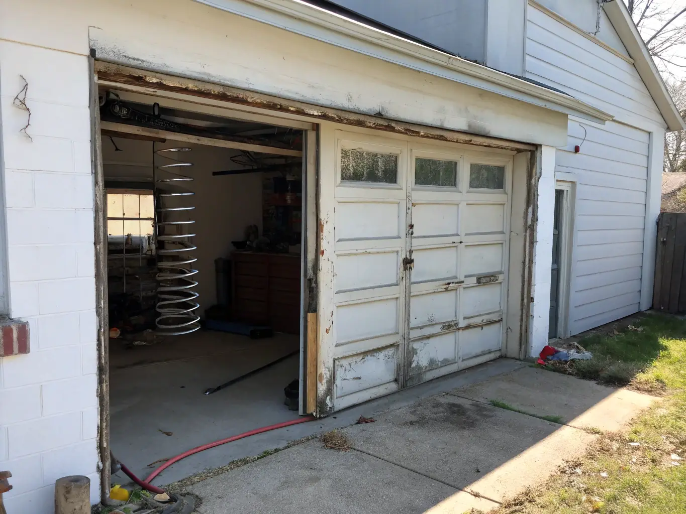 An image of a garage door opener with visible signs of damage or malfunction, such as frayed wires or a cracked casing. The photo should highlight the complexity of the opener mechanism.