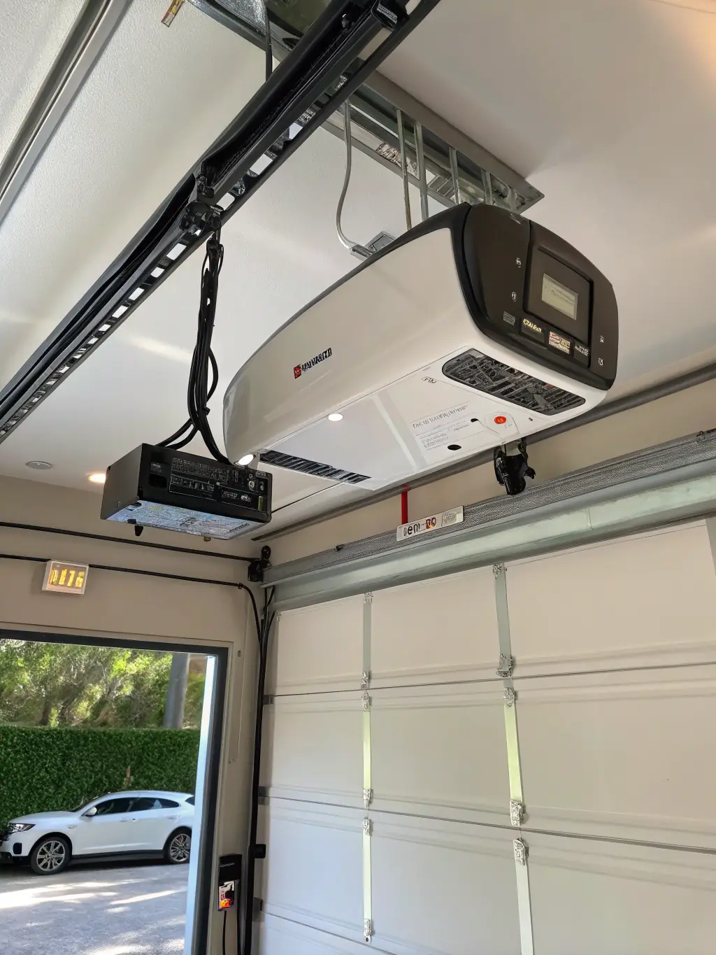 A well-lit image of an automated garage door system, showcasing the motor, remote control, and safety sensors, installed in a modern Swansea home.